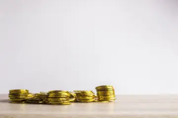 Golden coins scattered on a table, symbolizing the gold market discussed in the article.