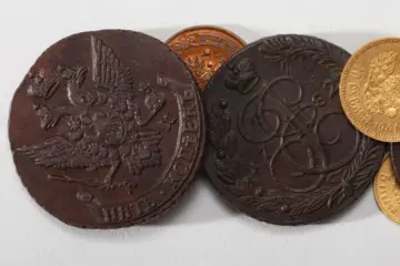 Collectible coins made of silver, gold, and copper on a wooden table, highlighting numismatics.