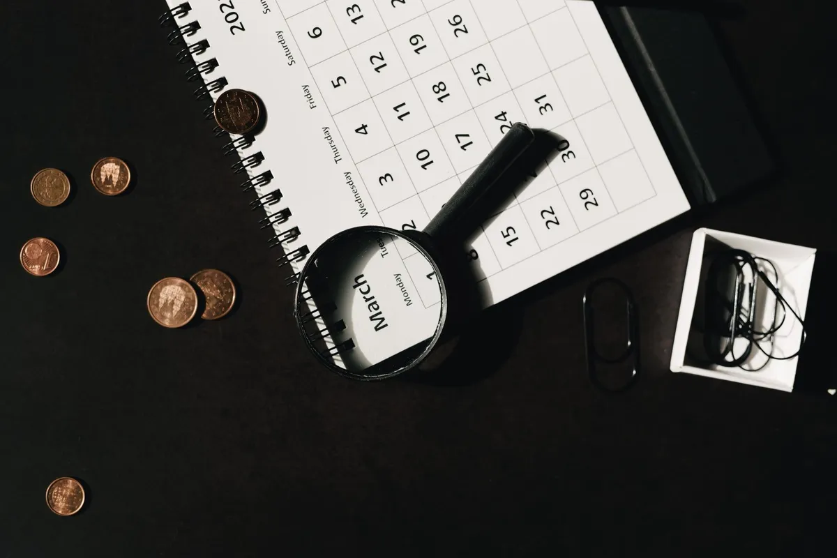 A calendar with a magnifying glass and coins, symbolizing the search for hidden value in rare coins.